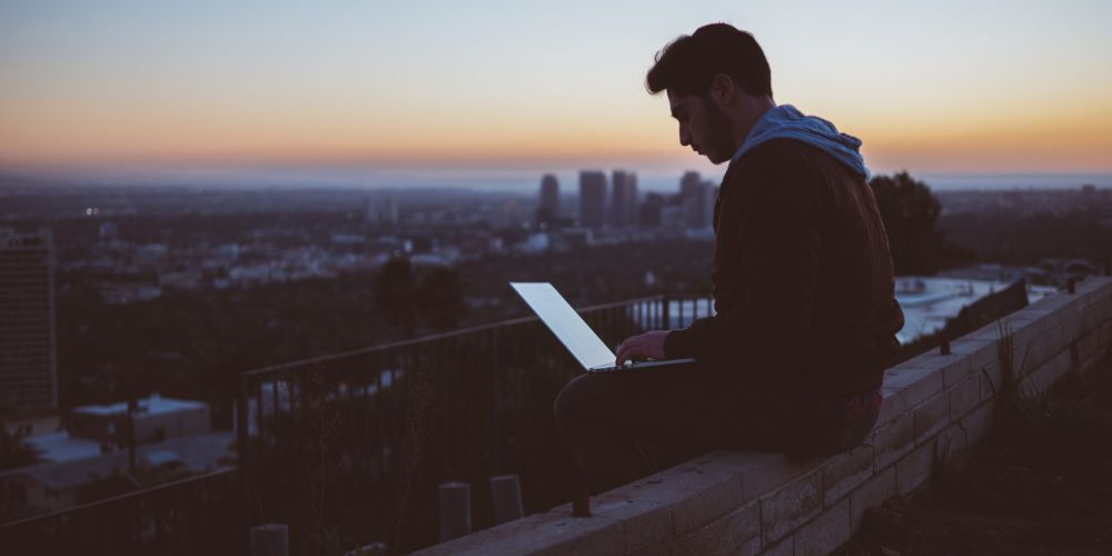 Digital nomad sur le toit avec vue panoramique pour illustrer un article sur comment devenir digital nomad.